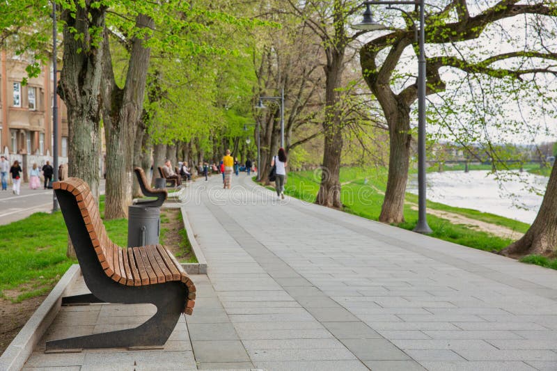 People walk on embankment of the Uzh river. Uzhhorod, Ukraine