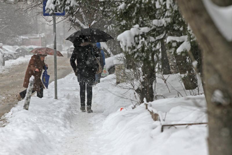 People walk on a very snowy sidewalk during snowstorm in the city of Sofia, Bulgaria – feb 26,2018. royalty free stock images People walk on a very snowy sidewalk during snowstorm in the city of Sofia, Bulgaria – feb 26,2018. royalty free stock images