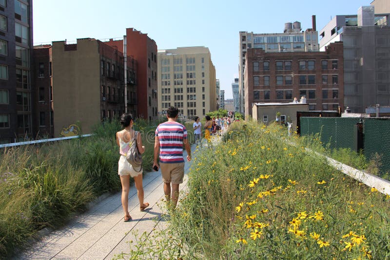People walk on the wooden path of Highline Park