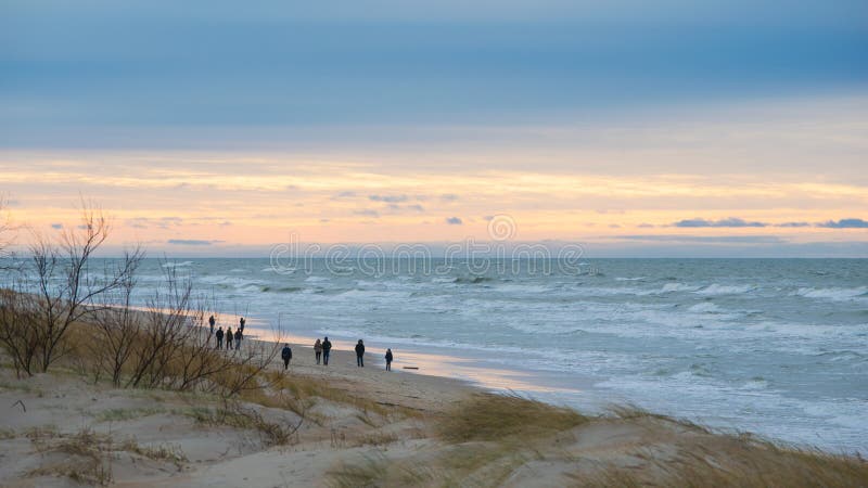 People walking on beach in winter evening in Palanga royalty free stock photos People walking on beach in winter evening in Palanga royalty free stock photos