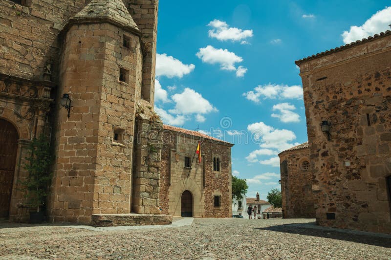 People walking in a cobblestone alley amidst gothic buildings at Caceres stock photography People walking in a cobblestone alley amidst gothic buildings at Caceres stock photography