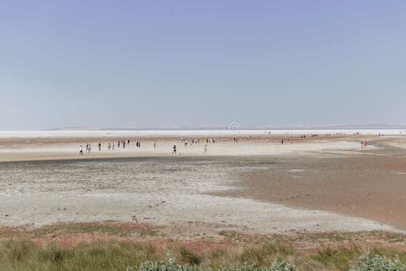 People walking on natural formation of drained salt lake.