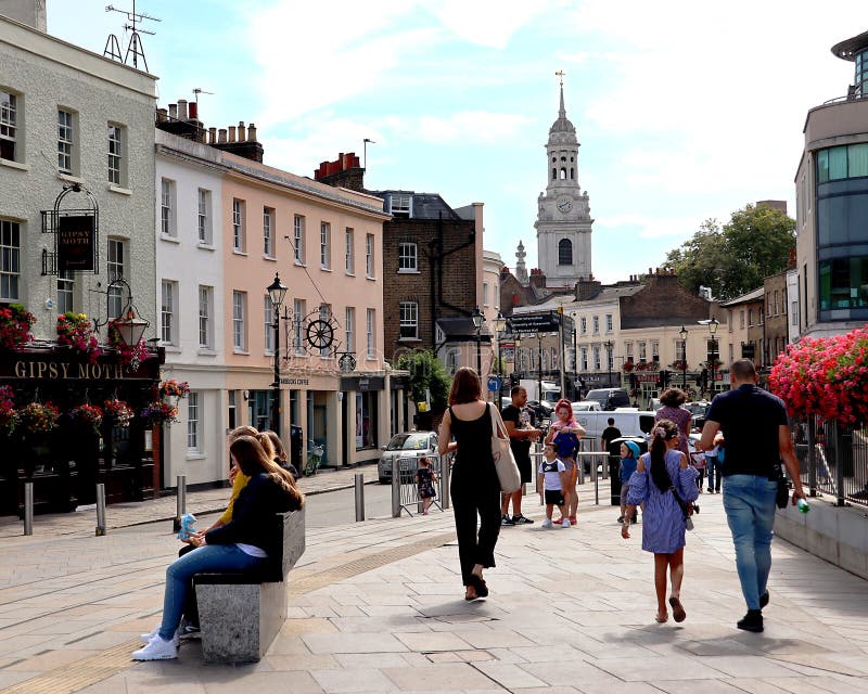 Busy street with shops and pubs in Greenwich, London.