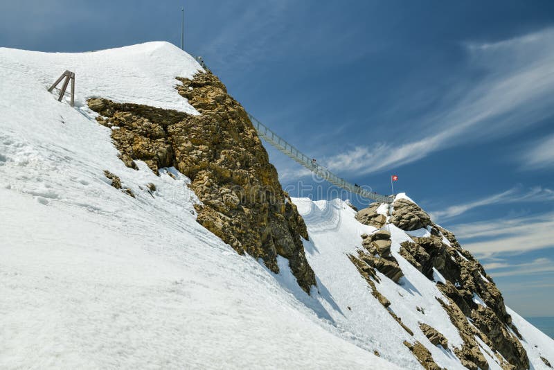 People walking on suspension bridge on Scex Rouge peak on top of Glacier 3000 stock image People walking on suspension bridge on Scex Rouge peak on top of Glacier 3000 stock image