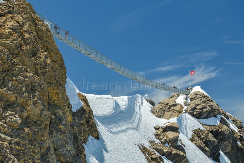 People walking on suspension bridge on Scex Rouge peak on top of Glacier 3000 stock photos People walking on suspension bridge on Scex Rouge peak on top of Glacier 3000 stock photos