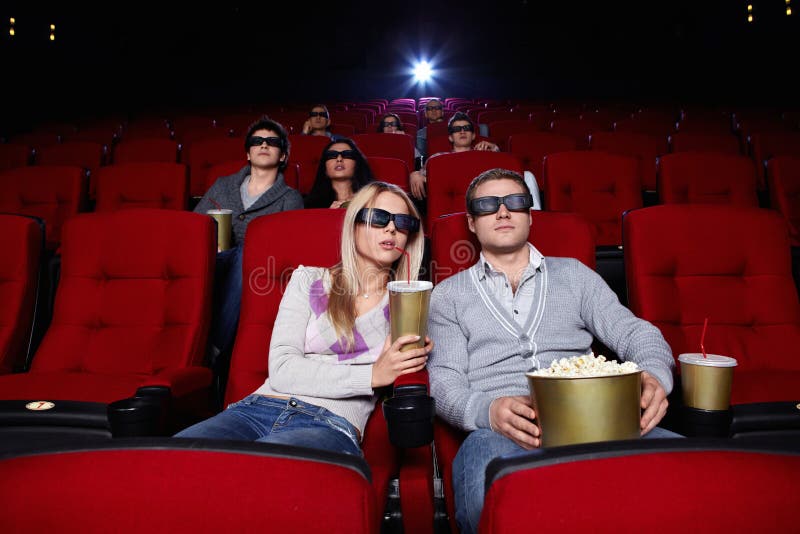 Mladí ľudia sledovať filmy v 3D okuliare do kina.