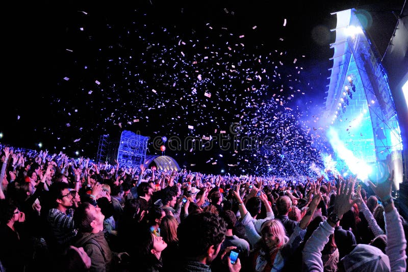 People watching a concert, while throwing confetti from the stage at Heineken Primavera Sound 2013 Festival