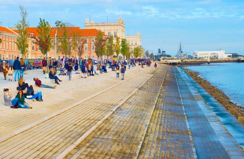 LISBON, PORTUGAL - DECEMBER 10, 2016: People resting on the embankment of Lisbon - famous tourist attraction. LISBON, PORTUGAL - DECEMBER 10, 2016: People resting on the embankment of Lisbon - famous tourist attraction.