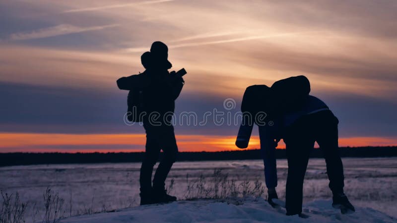 People winter silhouette photograph joy snow sunlight. group of tourists walking on top of a sunset silhouette mountain