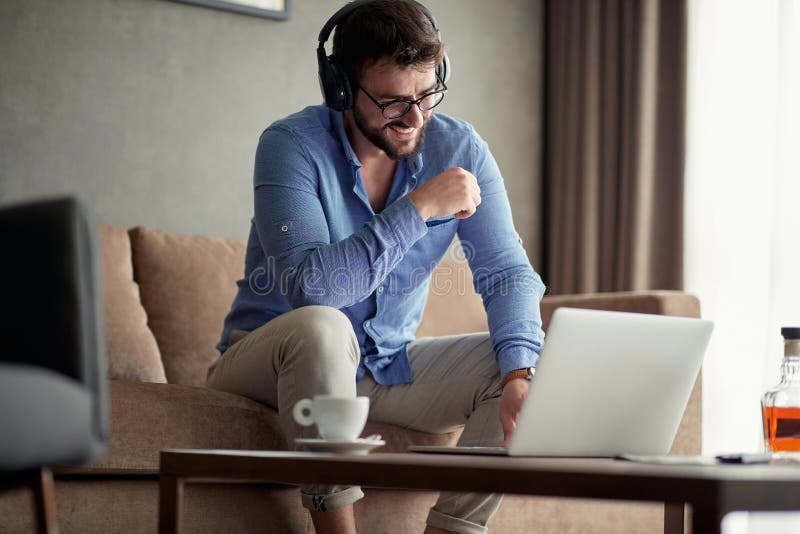 People working at home- man uses a laptop to listen to music and