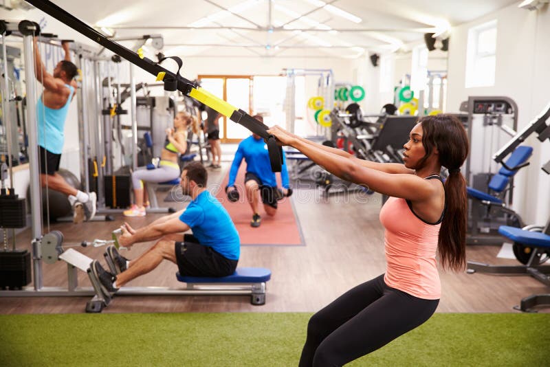 People working out on fitness equipment at a busy gym
