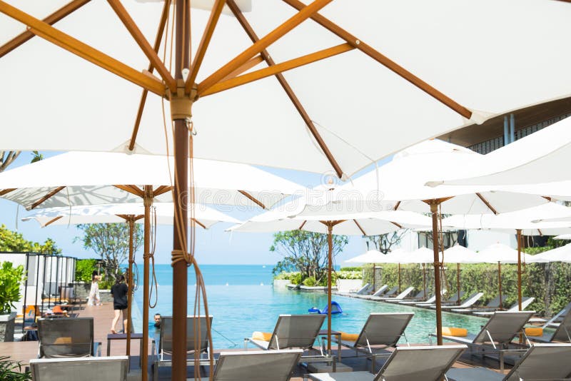 People relaxing and enjoy a luxury infinity swimming pool in the beach hotel