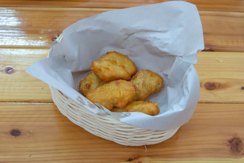 Pepitas de frango frito em uma cesta em uma tabela de madeira imagens de stock Pepitas de frango frito em uma cesta em uma tabela de madeira imagens de stock