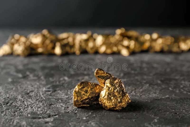 Pepitas de ouro na tabela escura
