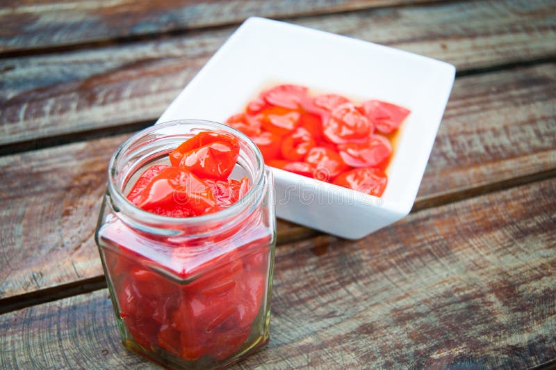 Peppadew en la placa blanca y el tarro pequeños imagenes de archivo Peppadew en la placa blanca y el tarro pequeños imagenes de archivo