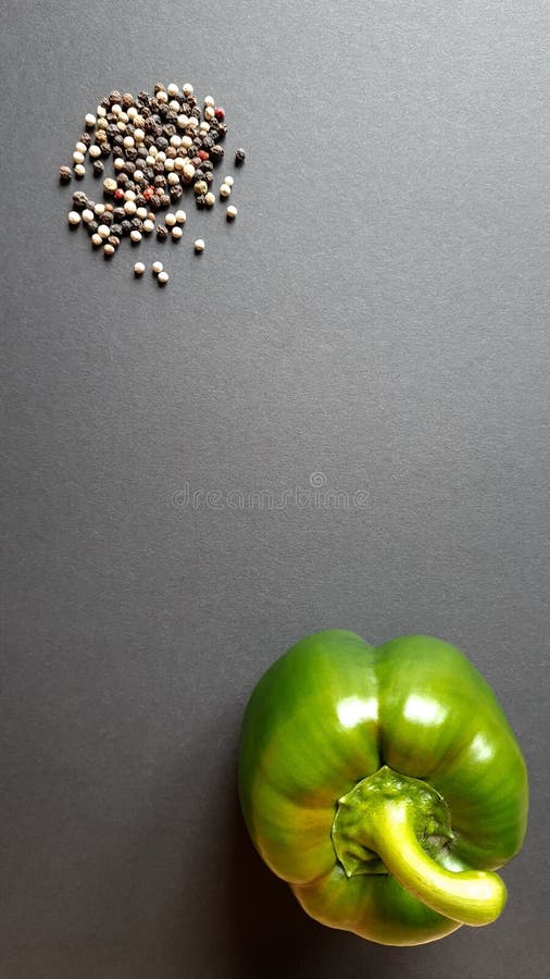 Peppercorns with Fresh Green Pepper on a Black Background Stock Photo