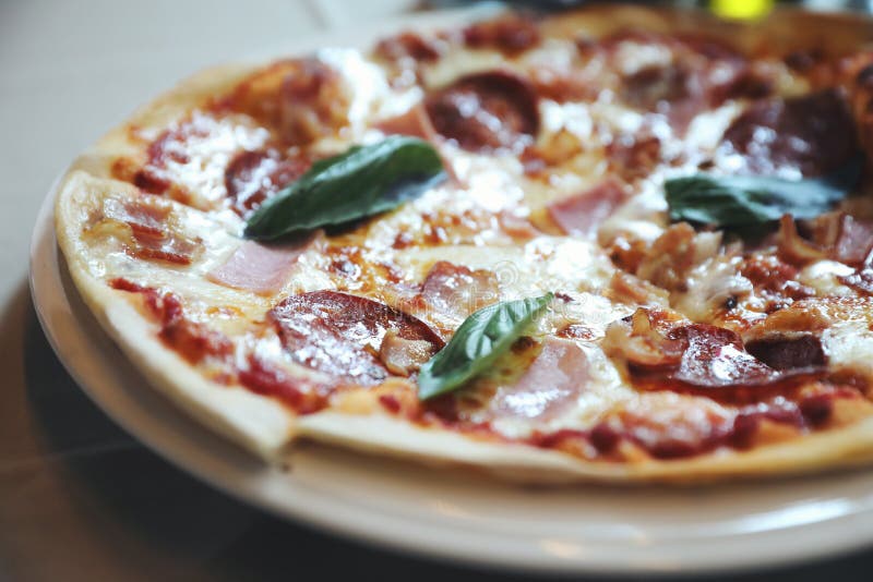 Pepperoni Bacon and Ham Pizza in Restaurant Background Stock Photo