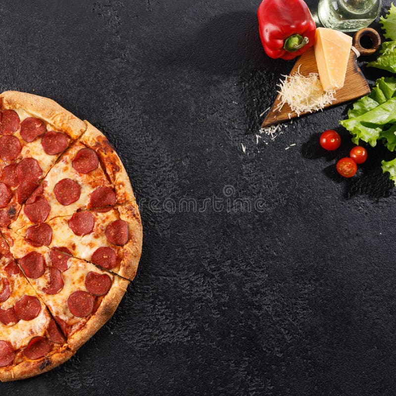 Pepperoni pizza on a black texture background. Still life. Top view. Square royalty free stock photo