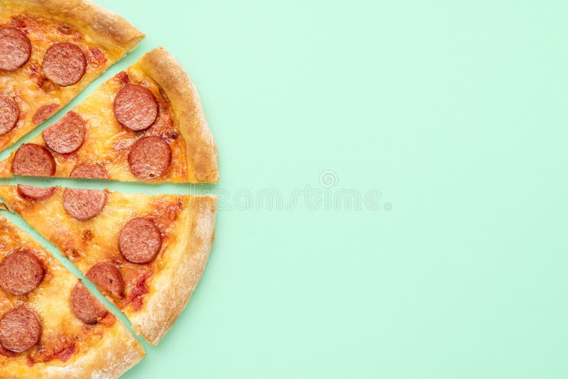 Pepperoni pizza top view. Sliced pizza isolated on a green background