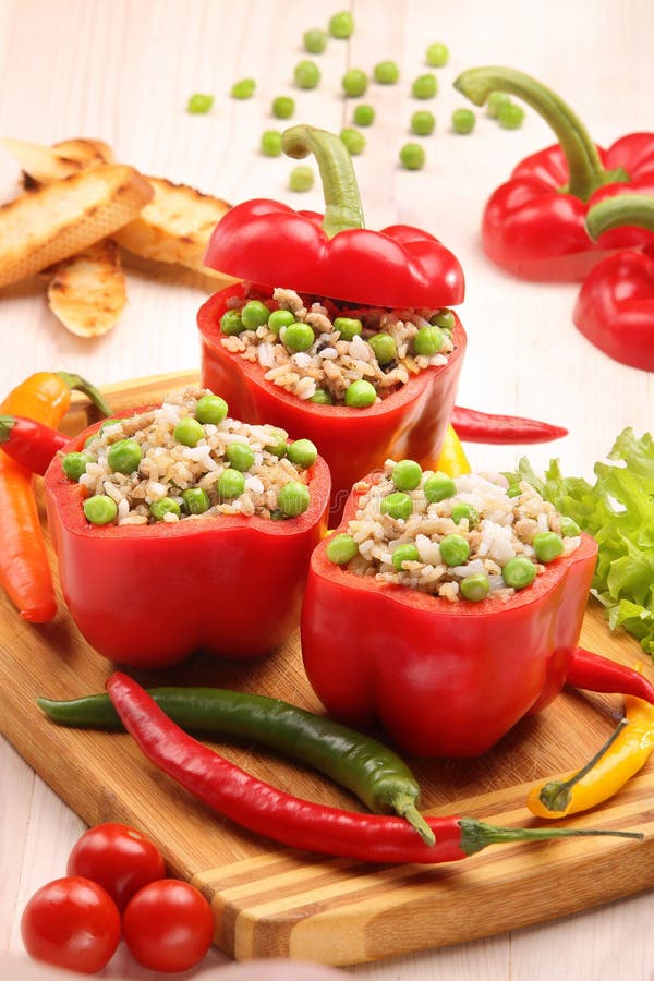 Peppers stuffed with meat rice and vegetables on cutting board stock photo Peppers stuffed with meat rice and vegetables on cutting board stock photo