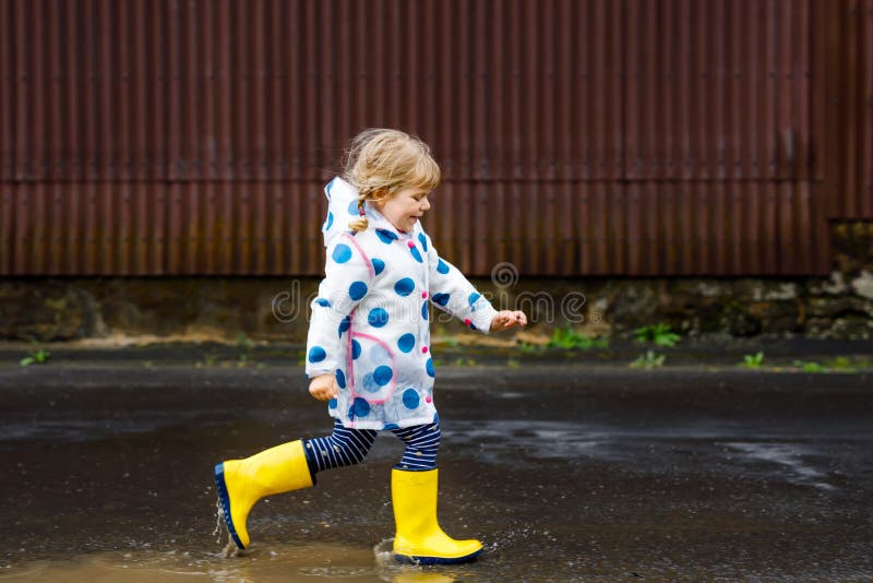 Pequeña Niña Pequeña Con Botas De Amarillas Corriendo Caminando Durante El En Un Día Lluvioso Nublado. Niño Feliz L Foto de archivo - Imagen de hija, piernas: