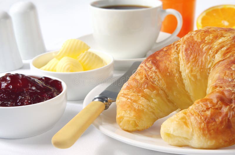 Continental breakfast with croissants, strawberry jam, butter curls, coffee and orange juice. Continental breakfast with croissants, strawberry jam, butter curls, coffee and orange juice.