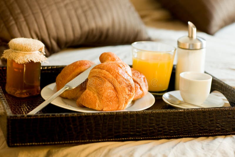 Photo of tray with breakfast food on the bed inside a bedroom. Photo of tray with breakfast food on the bed inside a bedroom