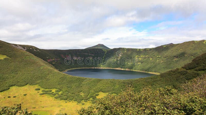 Small round lake inside the crater of the extinct volcano. Kamchatka Peninsula, Russia. Small round lake inside the crater of the extinct volcano. Kamchatka Peninsula, Russia.