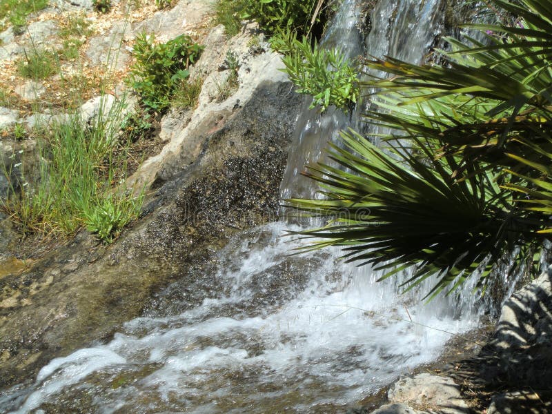 Pequeña cascada sobre rocas y plantas imágenes de archivo libres de regalías Pequeña cascada sobre rocas y plantas imágenes de archivo libres de regalías