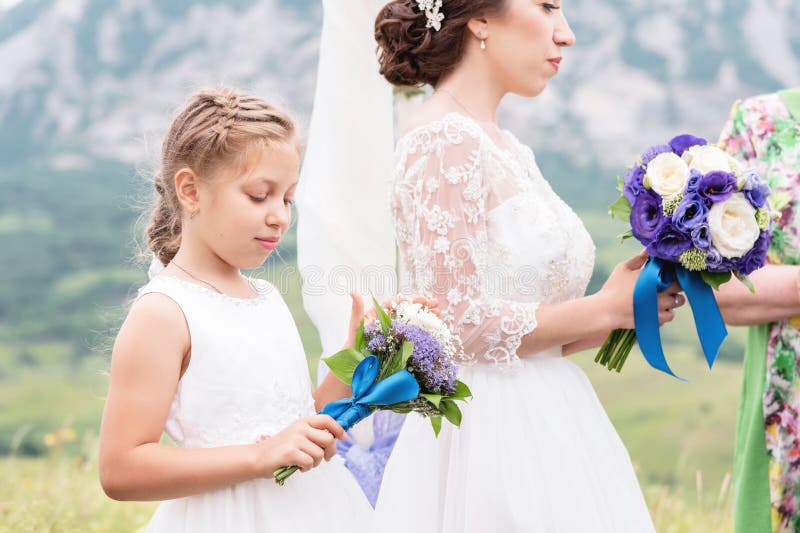 Pequeña hija al lado de su madre que está consiguiendo casada foto de archivo