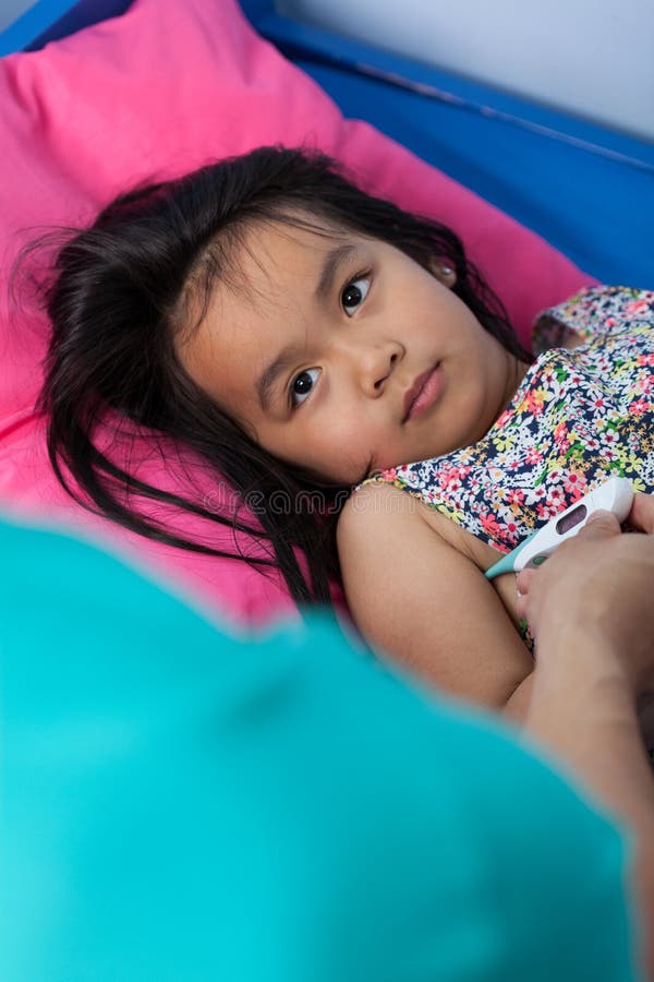 Pequeña muchacha asiática con fiebre fotografía de archivo libre de regalías Pequeña muchacha asiática con fiebre fotografía de archivo libre de regalías