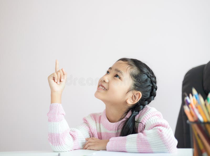 Pequeña muchacha asiática del retrato que señala el finger y la sonrisa con felicidad con la profundidad baja del foco selecto de fotografía de archivo Pequeña muchacha asiática del retrato que señala el finger y la sonrisa con felicidad con la profundidad baja del foco selecto de fotografía de archivo