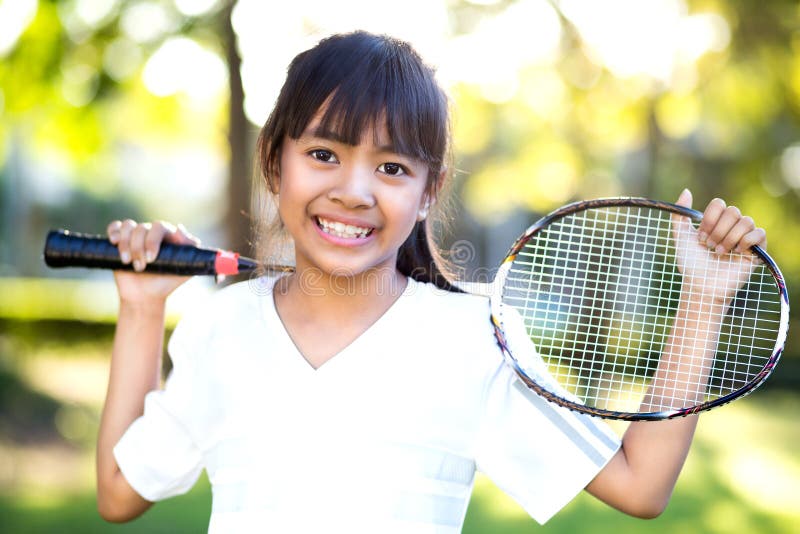 Pequeña muchacha asiática que sostiene una estafa de bádminton imagenes de archivo Pequeña muchacha asiática que sostiene una estafa de bádminton imagenes de archivo