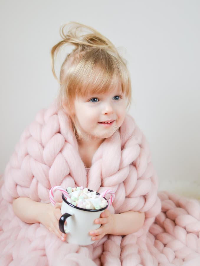 Pequeña muchacha caucásica hermosa que sostiene la taza con la Navidad que espera y el Año Nuevo, pastel combinado de lana merino fotos de archivo Pequeña muchacha caucásica hermosa que sostiene la taza con la Navidad que espera y el Año Nuevo, pastel combinado de lana merino fotos de archivo