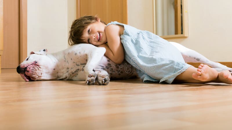 Pequeña muchacha feliz en el piso con el perro imágenes de archivo libres de regalías Pequeña muchacha feliz en el piso con el perro imágenes de archivo libres de regalías