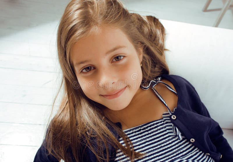 Pequeña muchacha linda en casa que sonríe fotos de archivo libres de regalías Pequeña muchacha linda en casa que sonríe fotos de archivo libres de regalías