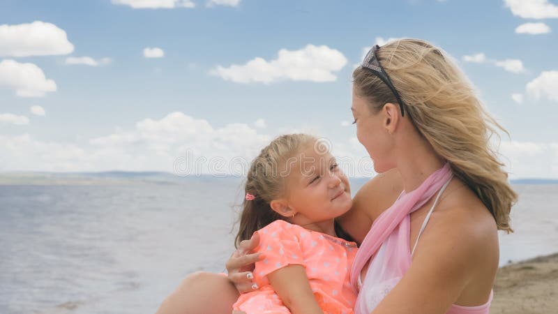 Pequeña muchacha linda y madre joven en la playa imágenes de archivo libres de regalías Pequeña muchacha linda y madre joven en la playa imágenes de archivo libres de regalías