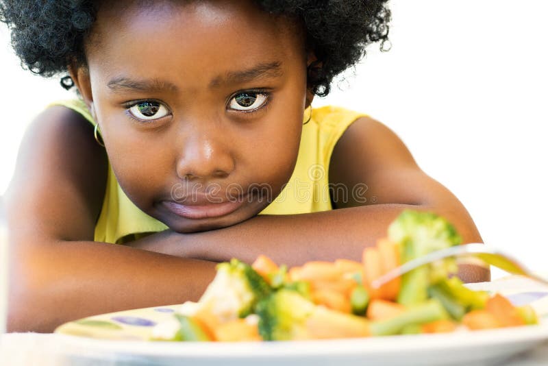 Pequeña muchacha negra que levanta la nariz para las verduras foto de archivo libre de regalías Pequeña muchacha negra que levanta la nariz para las verduras foto de archivo libre de regalías