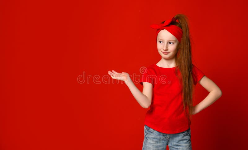 Peque?a muchacha pelirroja linda con un vendaje en su pelo, sonrisas y lugares un punto para su anuncio imagen de archivo Peque?a muchacha pelirroja linda con un vendaje en su pelo, sonrisas y lugares un punto para su anuncio imagen de archivo