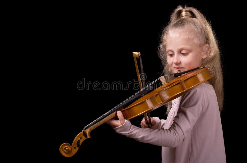 Pequeña muchacha rubia hermosa que toca el violín aislado en fondo negro foto de archivo libre de regalías Pequeña muchacha rubia hermosa que toca el violín aislado en fondo negro foto de archivo libre de regalías