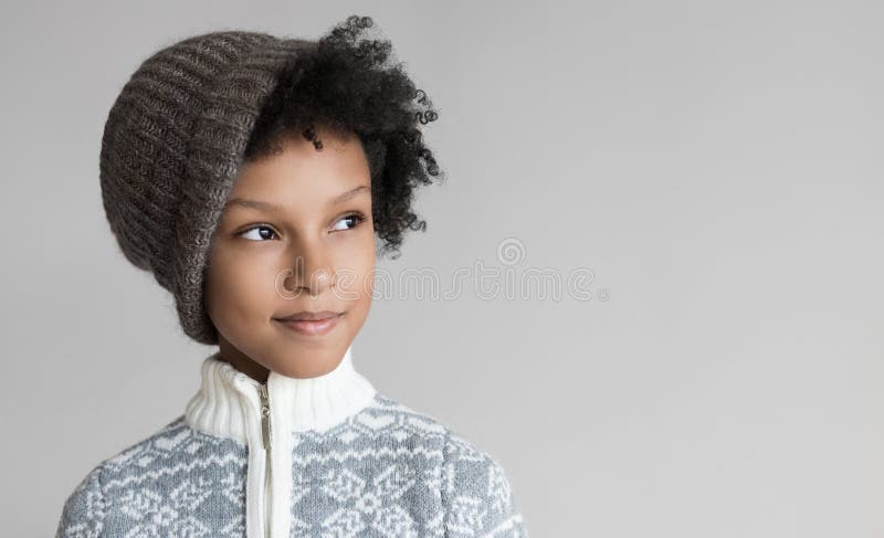 Pequeña niña linda mirando el retrato Un niño gracioso vestido con ropa de abrigo en estudio, aislado en fondo gris imagenes de archivo