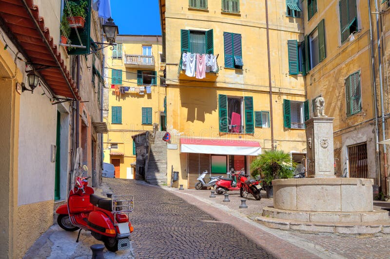 Pequeña plaza entre casas coloridas en Ventimiglia, Italia. imágenes de archivo libres de regalías Pequeña plaza entre casas coloridas en Ventimiglia, Italia. imágenes de archivo libres de regalías