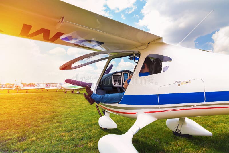Pequeño aeroplano con el piloto a bordo que espera en campo imagenes de archivo Pequeño aeroplano con el piloto a bordo que espera en campo imagenes de archivo