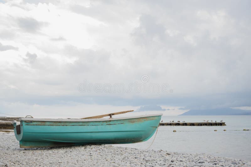 Pequeño barco azul pesquero de madera en la playa del Mar Negro de la costa del guijarro fotografía de archivo Pequeño barco azul pesquero de madera en la playa del Mar Negro de la costa del guijarro fotografía de archivo