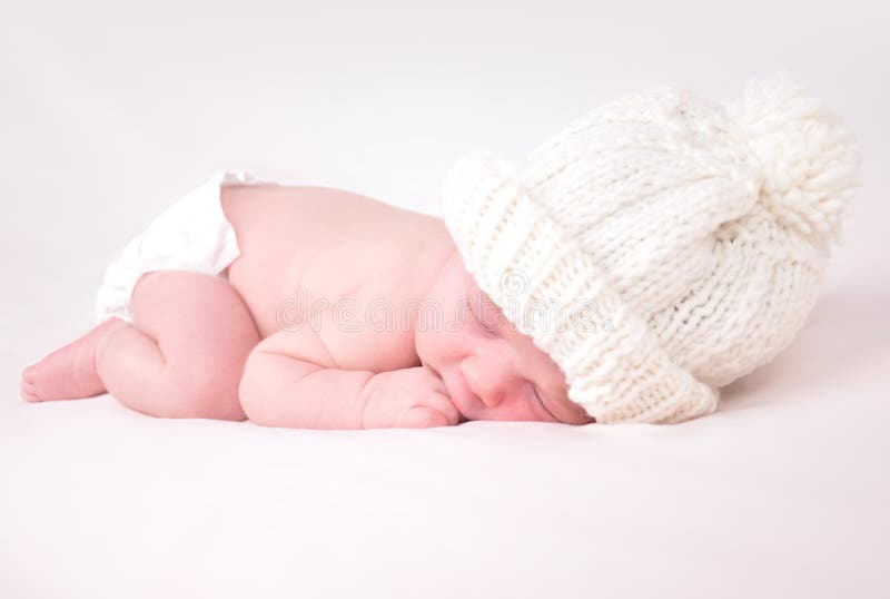 Pequeño bebé recién nacido que duerme en el fondo blanco fotografía de archivo libre de regalías Pequeño bebé recién nacido que duerme en el fondo blanco fotografía de archivo libre de regalías