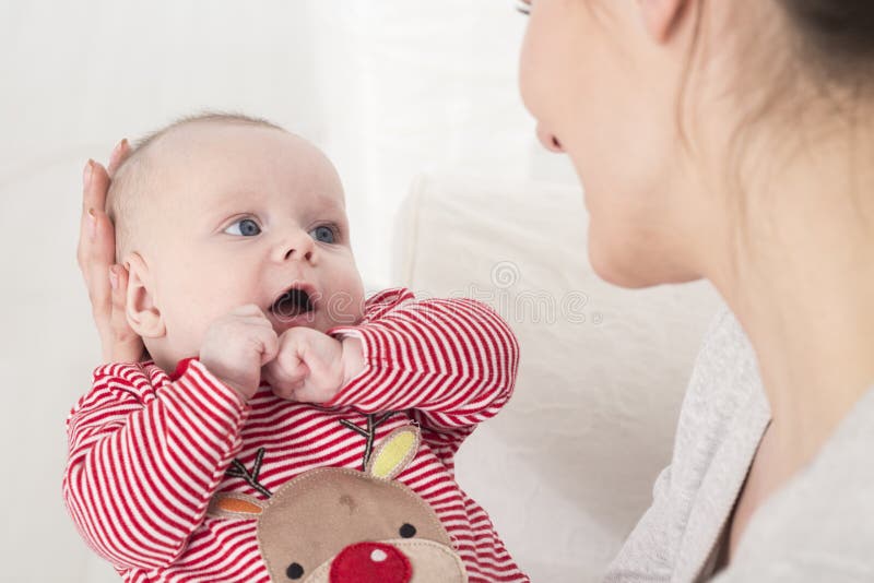 Pequeño bebé sorprendido que mira a la madre imagen de archivo libre de regalías Pequeño bebé sorprendido que mira a la madre imagen de archivo libre de regalías