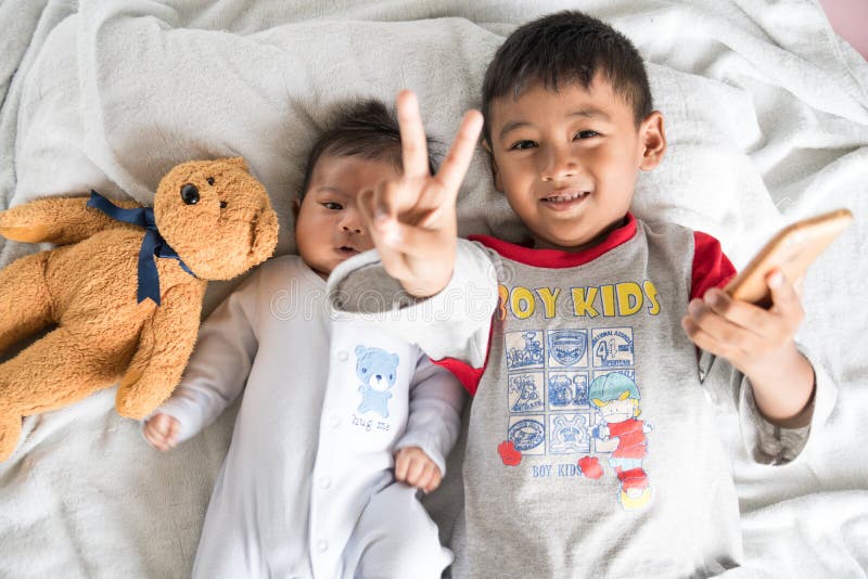 Pequeño Brother lindo Using Mobile Taking Selfie con su Brother foto de archivo libre de regalías Pequeño Brother lindo Using Mobile Taking Selfie con su Brother foto de archivo libre de regalías