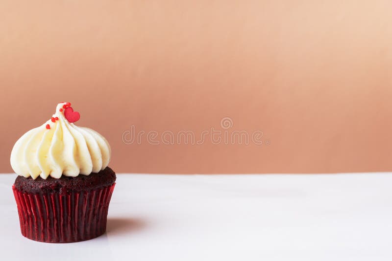Pequeño corazón rojo lindo en la magdalena poner crema blanca, concepto dulce del postre foto de archivo libre de regalías Pequeño corazón rojo lindo en la magdalena poner crema blanca, concepto dulce del postre foto de archivo libre de regalías