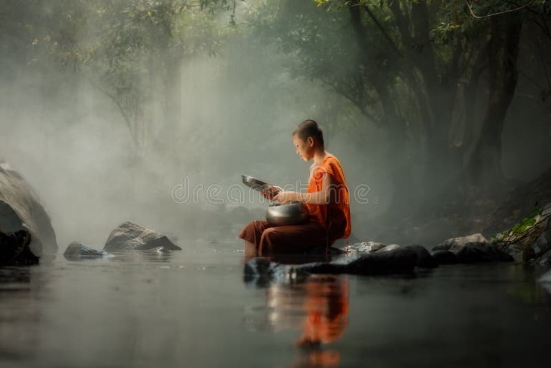 Pequeño monje de Tailandia que se sienta en The Creek o el río en bosque en imágenes de archivo libres de regalías Pequeño monje de Tailandia que se sienta en The Creek o el río en bosque en imágenes de archivo libres de regalías