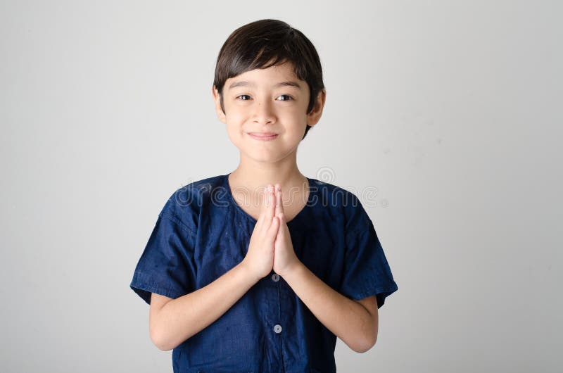 Pequeño muchacho asiático que ruega en traje tailandés foto de archivo Pequeño muchacho asiático que ruega en traje tailandés foto de archivo